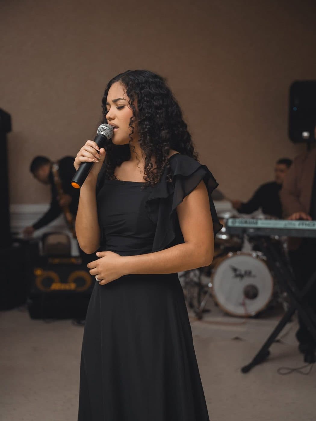 Elizabet Maria cantando con su banda en un servicio