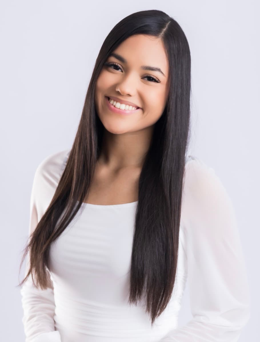 Retrato cercano de Elizabet Maria sonriendo, con blusa blanca